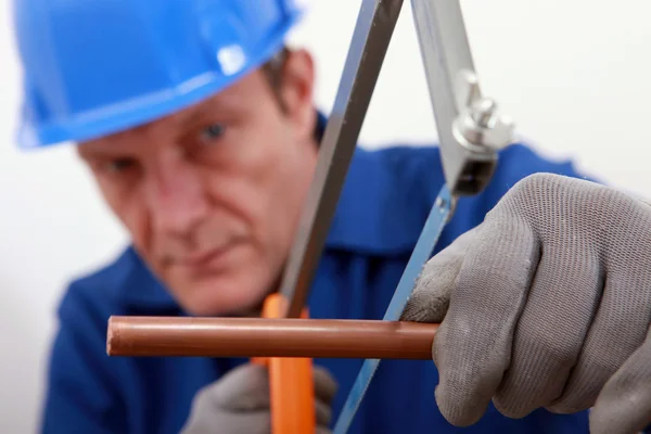 Loodgieter snijden koperen pijp — Stockfoto