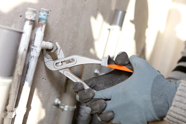 Craftsman screwing a pipe — Stock Photo, Image