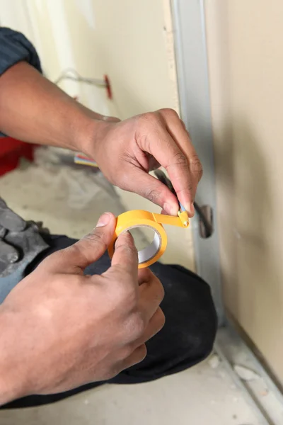 Trabalhador com fita adesiva amarela — Fotografia de Stock