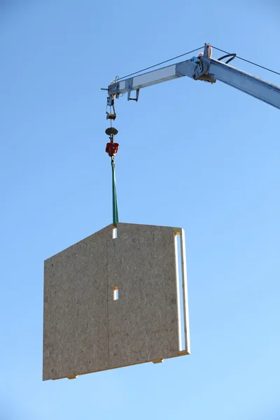 Grue soulevant un cadre de maison en bois — Photo