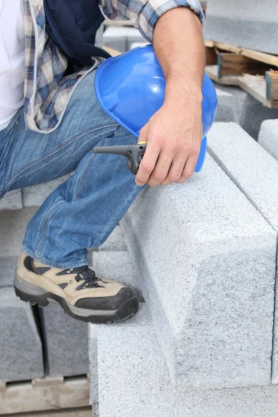 Trabajador de la construcción arrodillado por bloques de hormigón —  Fotos de Stock