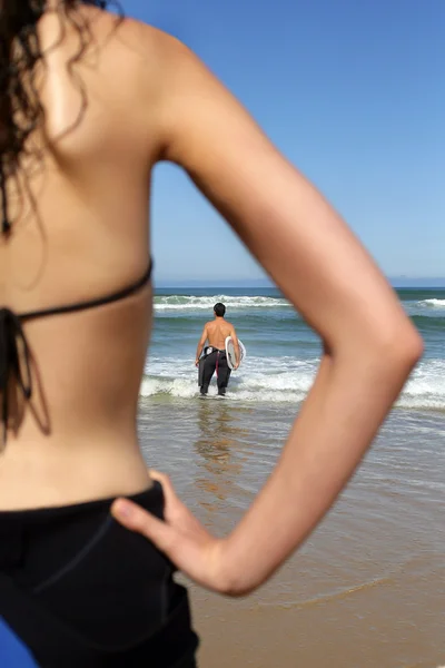 Vrouw kijken naar haar vriendje surfen — Stockfoto