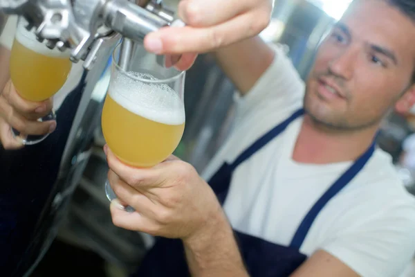 醸造所でバットからビールを注ぐ労働者は — ストック写真