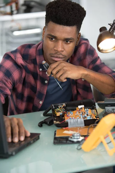 Techniker Repariert Ein Telefon Das Informationen Auf Einem Laptop Recherchiert — Stockfoto
