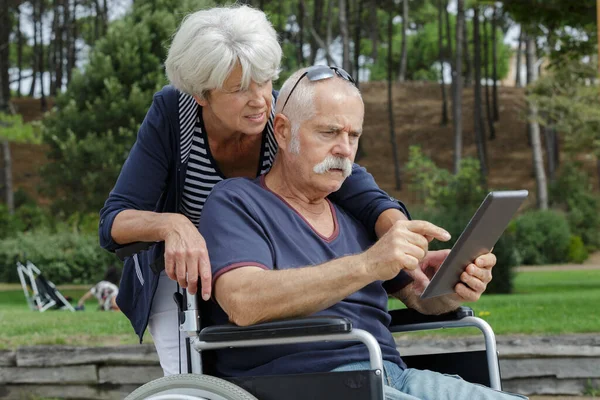 Pareja Ancianos Aire Libre Mirando Hombre Tableta Silla Ruedas — Foto de Stock