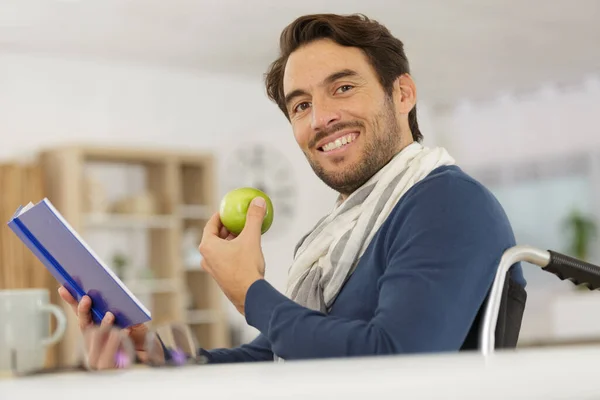 Boldog Fiatal Jóképű Férfi Tolószékben Eszik Egy Almát — Stock Fotó