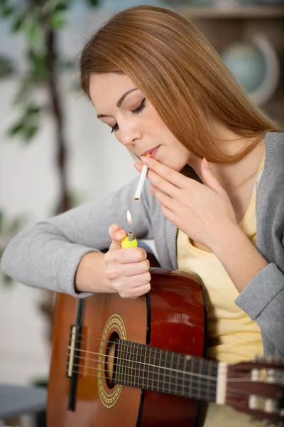 Fiatal Női Gitáros Cigarettát Gyújt — Stock Fotó