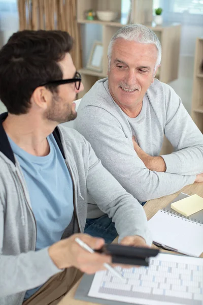 Senior Vader Volwassen Zoon Zoek Naar Rekenmachine — Stockfoto