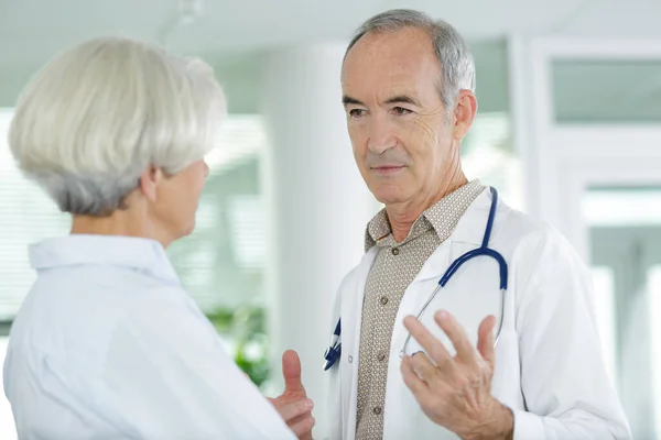 Médico Sénior Masculino Expresando Preocupaciones Salud Con Paciente Anciano —  Fotos de Stock