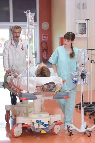 Medizinisches Personal Wälzt Patient Mit Tropf Und Monitor Auf Bett — Stockfoto