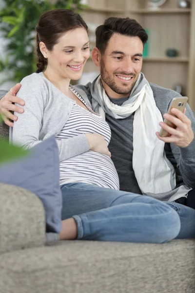 丈夫和怀孕的妻子与平板电脑在家里 — 图库照片