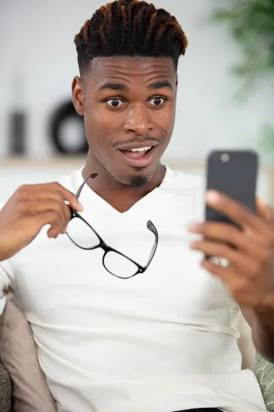 Porträtt Chockad Ung Man Tittar Mobiltelefon — Stockfoto