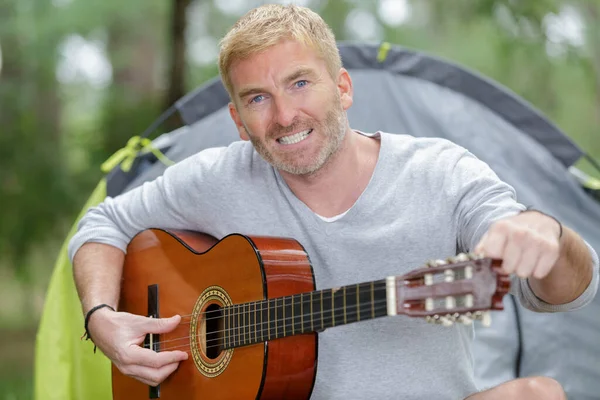 Mogen Man Tuning Gitarr Vid Sitt Tält — Stockfoto