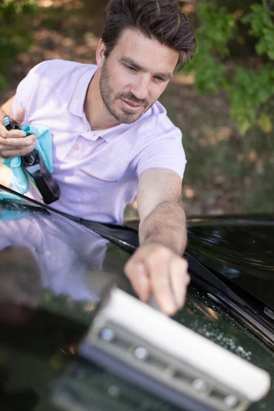 スポンジと泡で車を洗うハンサムな男 — ストック写真