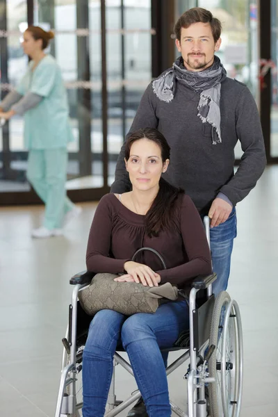 車椅子の女性と一緒に病院のロビーで — ストック写真