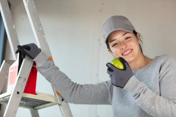 Vrouwelijke Handarbeider Door Een Trapladder Houdt Een Appel — Stockfoto