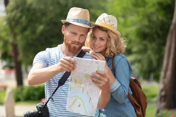 休暇中に地図を見ている若いカップルは — ストック写真