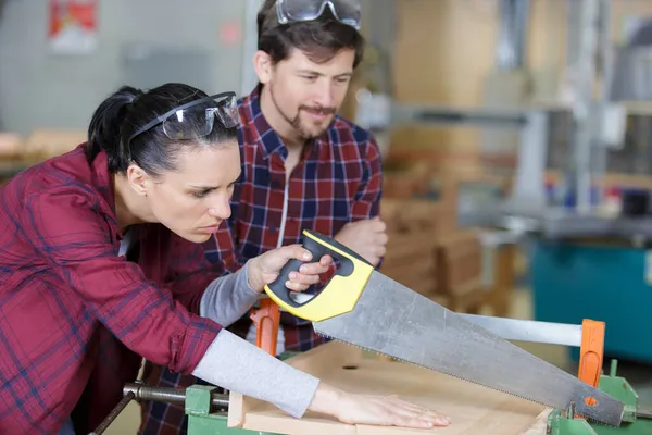 Female Carpenter Cutting Plank Hand Saw — Stock Photo, Image