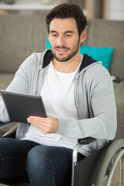 Homem Cadeira Rodas Casa Usando Tablet Digital — Fotografia de Stock