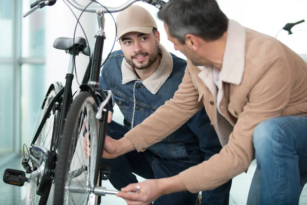 Człowiek Pomaga Dokręcić Nakrętkę Koła Rowerowego — Zdjęcie stockowe