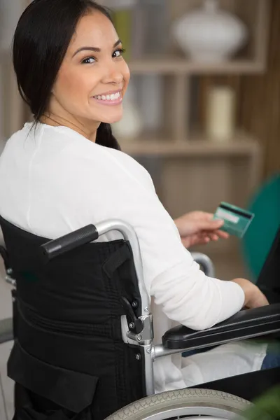 幸せな障害者の女性がノートパソコンにカード番号を入力して — ストック写真