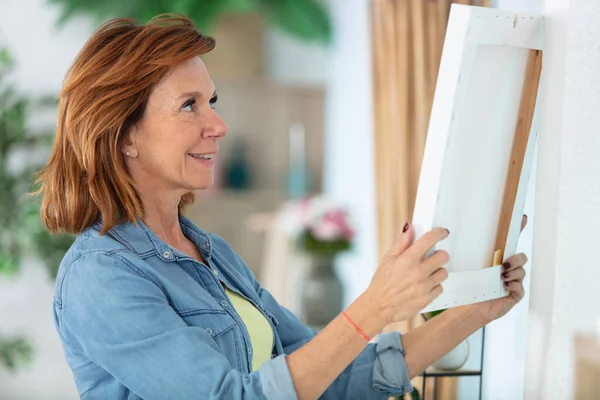 Mature Woman Hanging Picture Wall — Stock Photo, Image