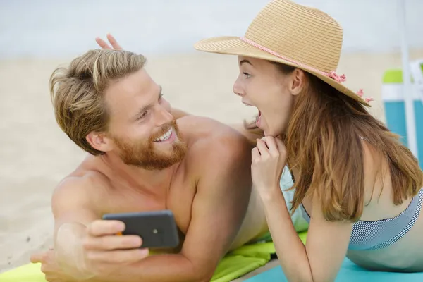 Ζευγάρι Στην Παραλία Γυναίκα Κάνοντας Χειρονομία Ενώ Λήψη Selfie — Φωτογραφία Αρχείου