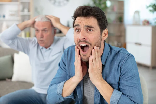 Glad Pensionerad Man Tittar Mästerskap Och Jublar Med Stilig Son — Stockfoto