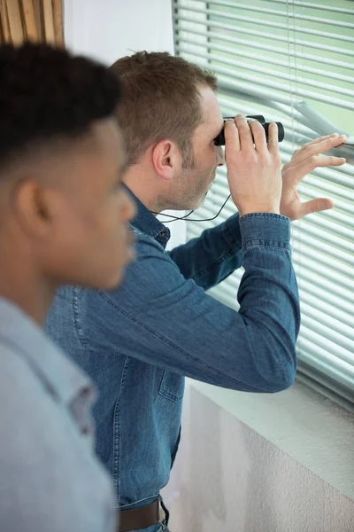 Hombres Preocupados Vigilando Través Ventana Con Prismáticos — Foto de Stock