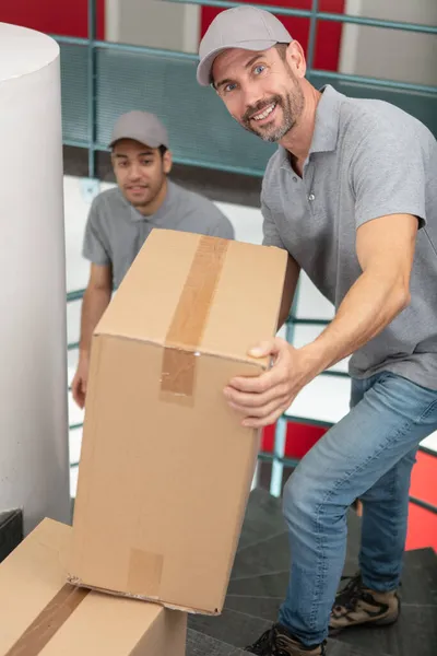 Young Couriers Standing Parcels Stairs Indoors — Stock Photo, Image