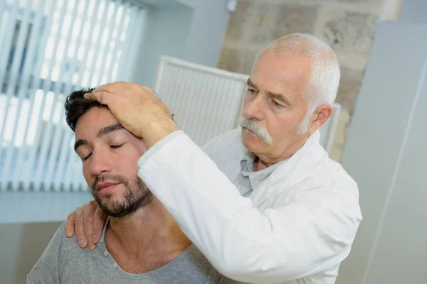 Seniorphysiotherapeut Bei Einer Kopfmassage — Stockfoto