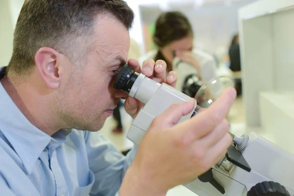 Een Man Die Een Microscoop Gebruikt — Stockfoto