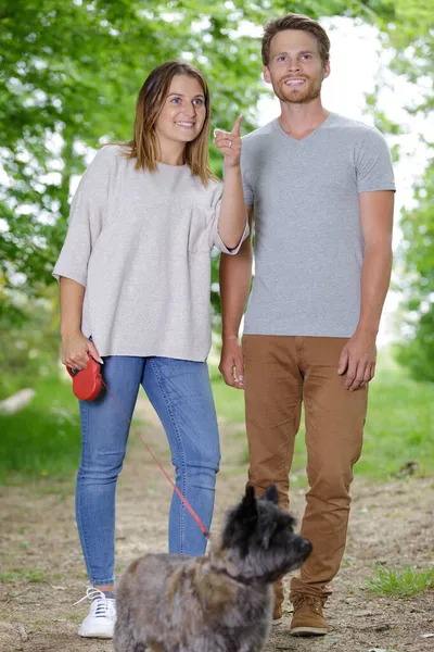 Een Jong Koppel Met Een Hond Wandelen Het Park Voorjaarsbijeenkomst — Stockfoto