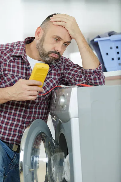 Deprimido Serviceman Trabalhando Máquina Lavar Roupa — Fotografia de Stock