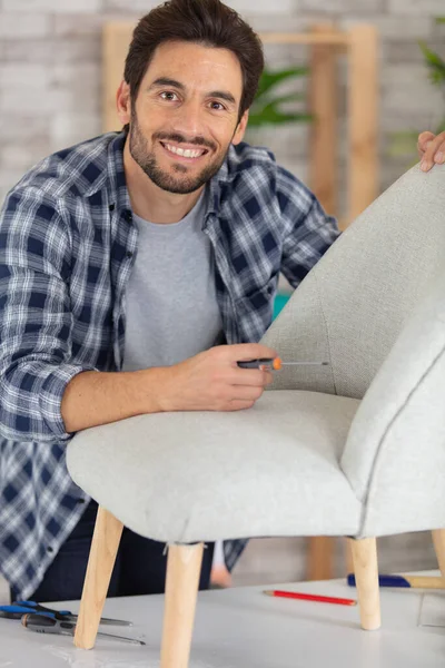 Νεαρός Άνδρας Επισκευάζει Μια Καρέκλα Στο Σπίτι — Φωτογραφία Αρχείου