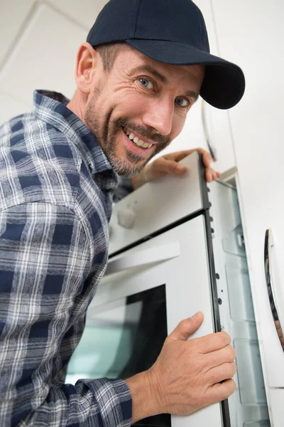 Hombre Feliz Instalando Horno Una Cocina Equipada — Foto de Stock