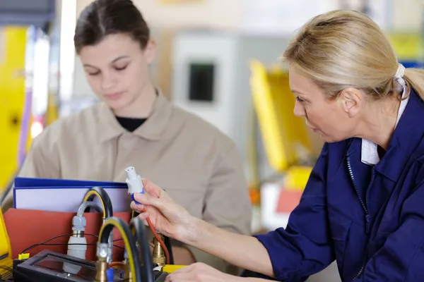 Ingenieurin Verbindet Schläuche Mit Lehrling — Stockfoto