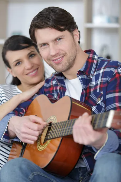 Joven Pareja Jugando Guitarra Sofá Interior —  Fotos de Stock