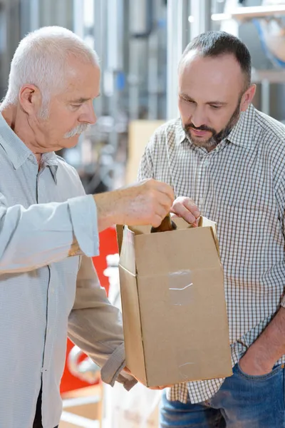 Hombre Mayor Con Colega Tomando Botella Caja Cartón — Foto de Stock