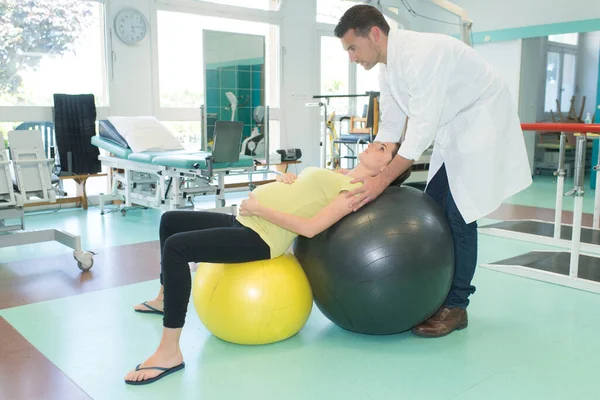 Quadro Mulher Grávida Exercitando Com Bola Ajudada Pelo Fisioterapeuta — Fotografia de Stock