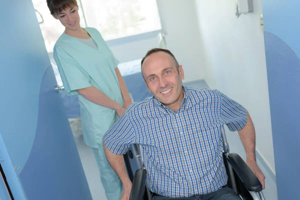 Krankenschwester Schiebt Patienten Rollstuhl — Stockfoto