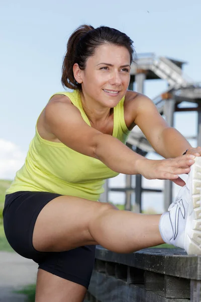 Kadın Dışarıda Egzersiz Yaparken Bacağını Esnetiyor — Stok fotoğraf