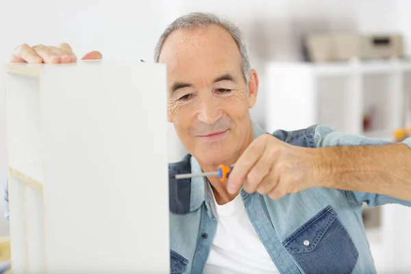 Älterer Mann Mit Einem Schraubenzieher Für Die Herstellung Eines Regals — Stockfoto