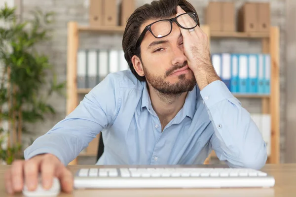 Joven Barbudo Sentado Escritorio Buscando Somnoliento — Foto de Stock