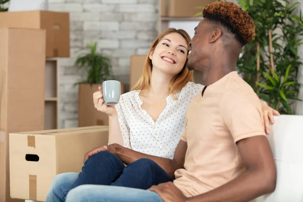 happy couple relaxing on sofa having fun on moving day