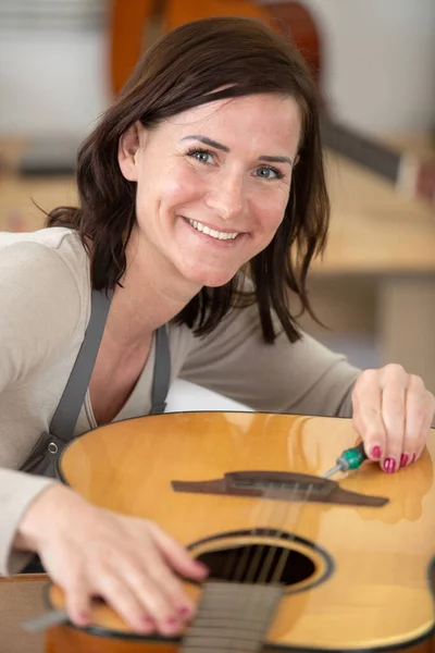 Жінка Ремонтує Акустичну Гітару — стокове фото