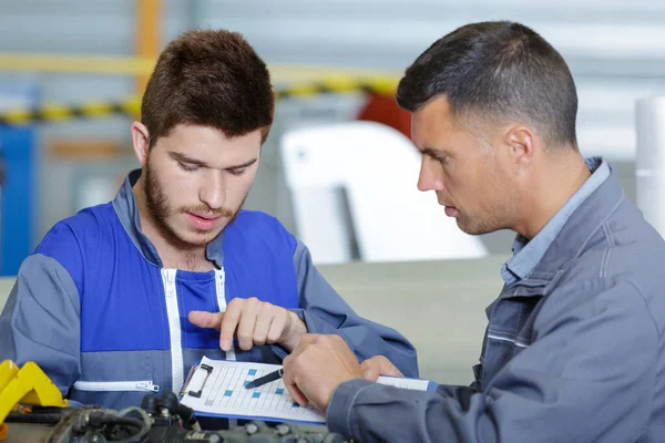 Young Engineer Pointing Mentors Clipboard — Stock Photo, Image