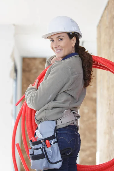 Happy Female Builder Holding Pipes — Stockfoto