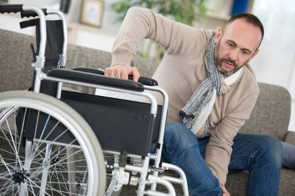 Disabled Man Trying Sit Wheelchair — 图库照片