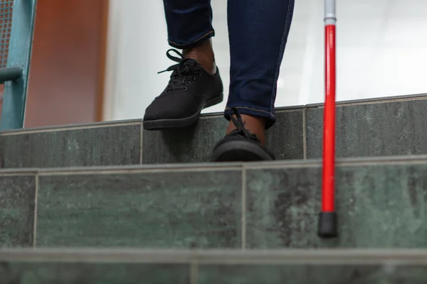 close up of blind person negotiating steps using cane